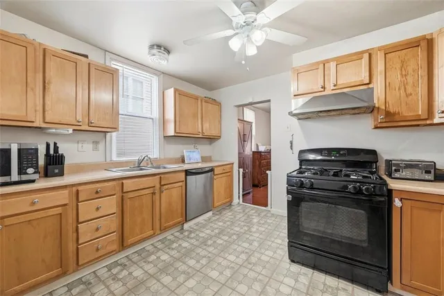 a kitchen with granite countertop a stove top oven sink and cabinets