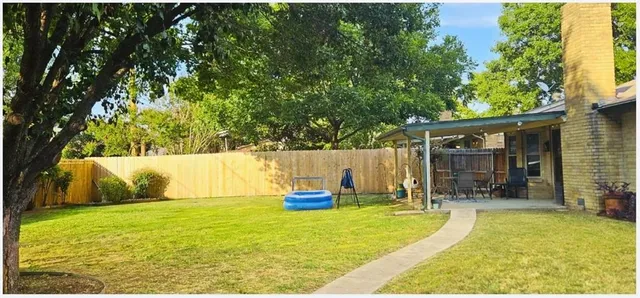 a view of a swimming pool with a patio and a yard