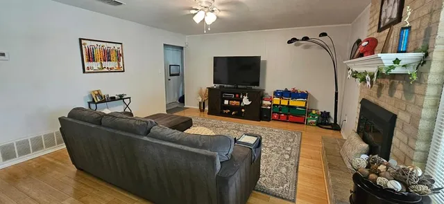 a living room with furniture a flat screen tv and a fireplace