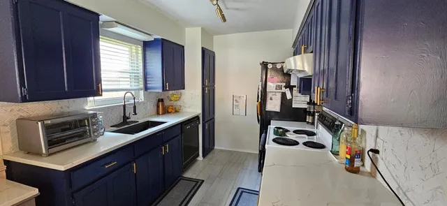 a kitchen with a stove a sink and a refrigerator