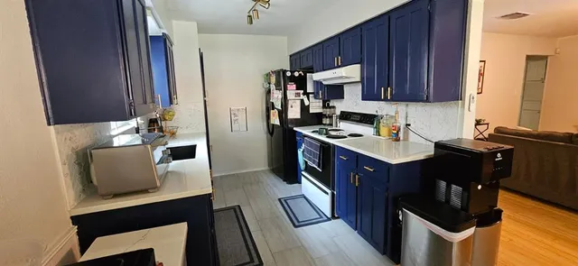 a kitchen with sink a microwave a refrigerator and cabinets