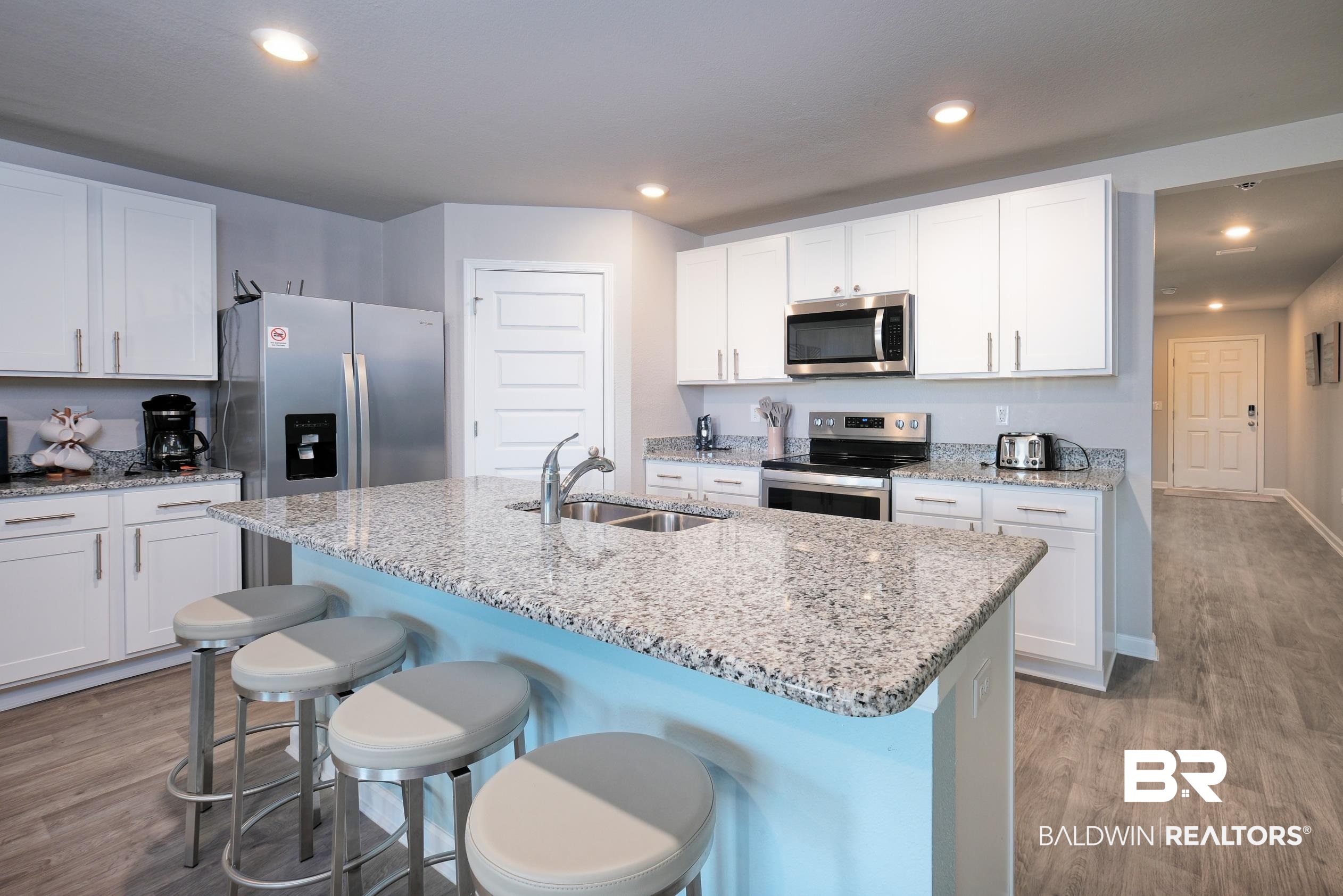 7425 Coppin Drive Foley, AL 36535 - Photo 5 of 41 Kitchen featuring appliances with stainless steel finishes, sink, light wood-type flooring, an island with sink, and white cabinets