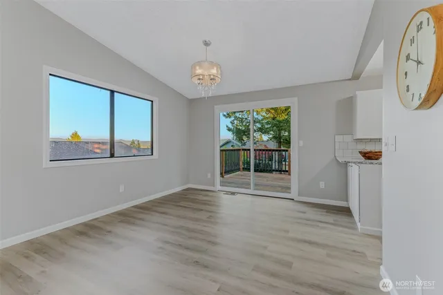a view of empty room with wooden floor and window