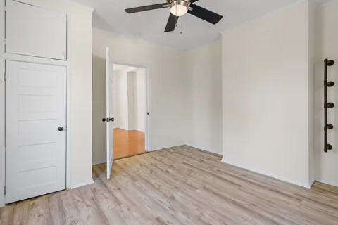 an empty room with wooden floor closet and windows