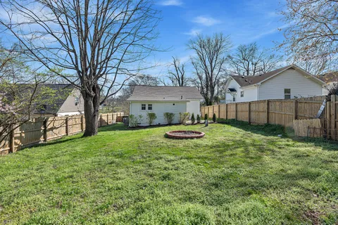 a view of a house with backyard and a tree