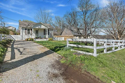 a view of a house with backyard and a tree