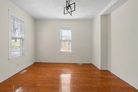 a view of a room with wooden floor and windows