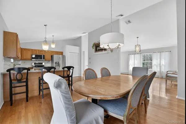 a dining room with furniture a chandelier and wooden floor