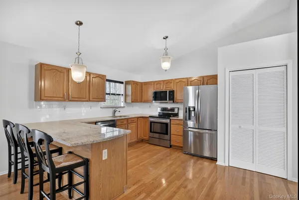 a kitchen with stainless steel appliances granite countertop a sink refrigerator and microwave