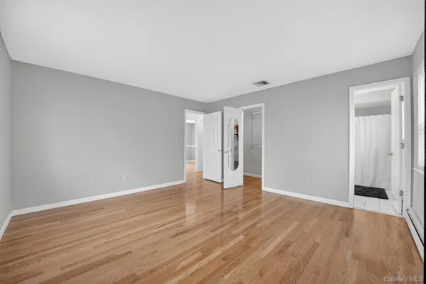 a view of an empty room with wooden floor