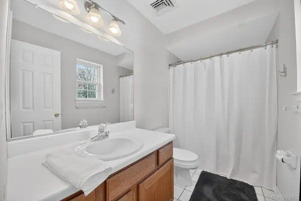 a bathroom with a granite countertop sink toilet and a mirror