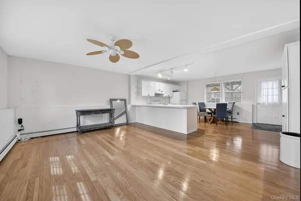 a view of a livingroom with furniture wooden floor and a ceiling fan
