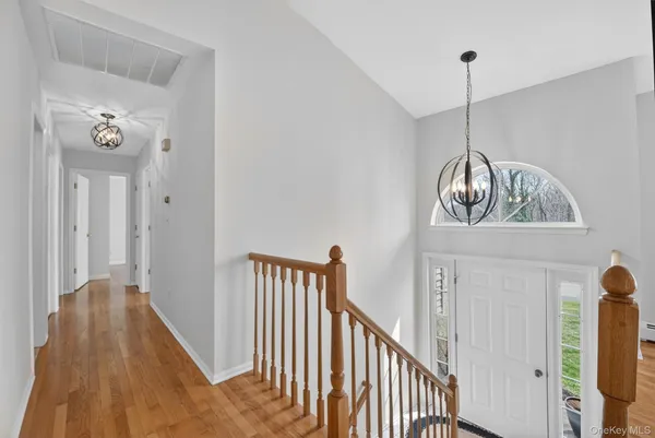 a view of a hallway with wooden floor and stairs