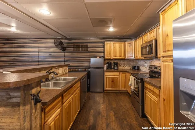 a kitchen with a sink cabinets stainless steel appliances and a window