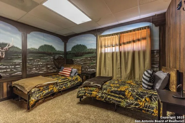 a bedroom with furniture and large windows