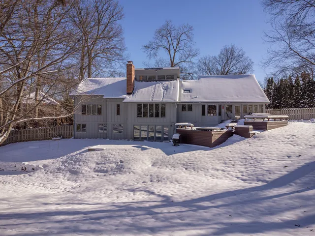 a front view of a house with a yard covered with snow