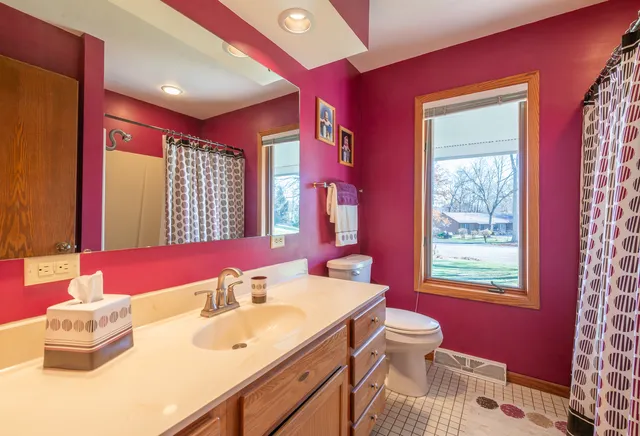 a bathroom with a bathtub sink vanity mirror and a toilet