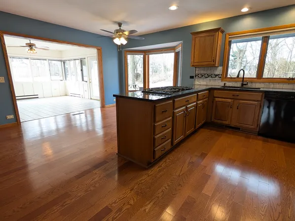 a kitchen with stainless steel appliances granite countertop a stove a sink and a large window
