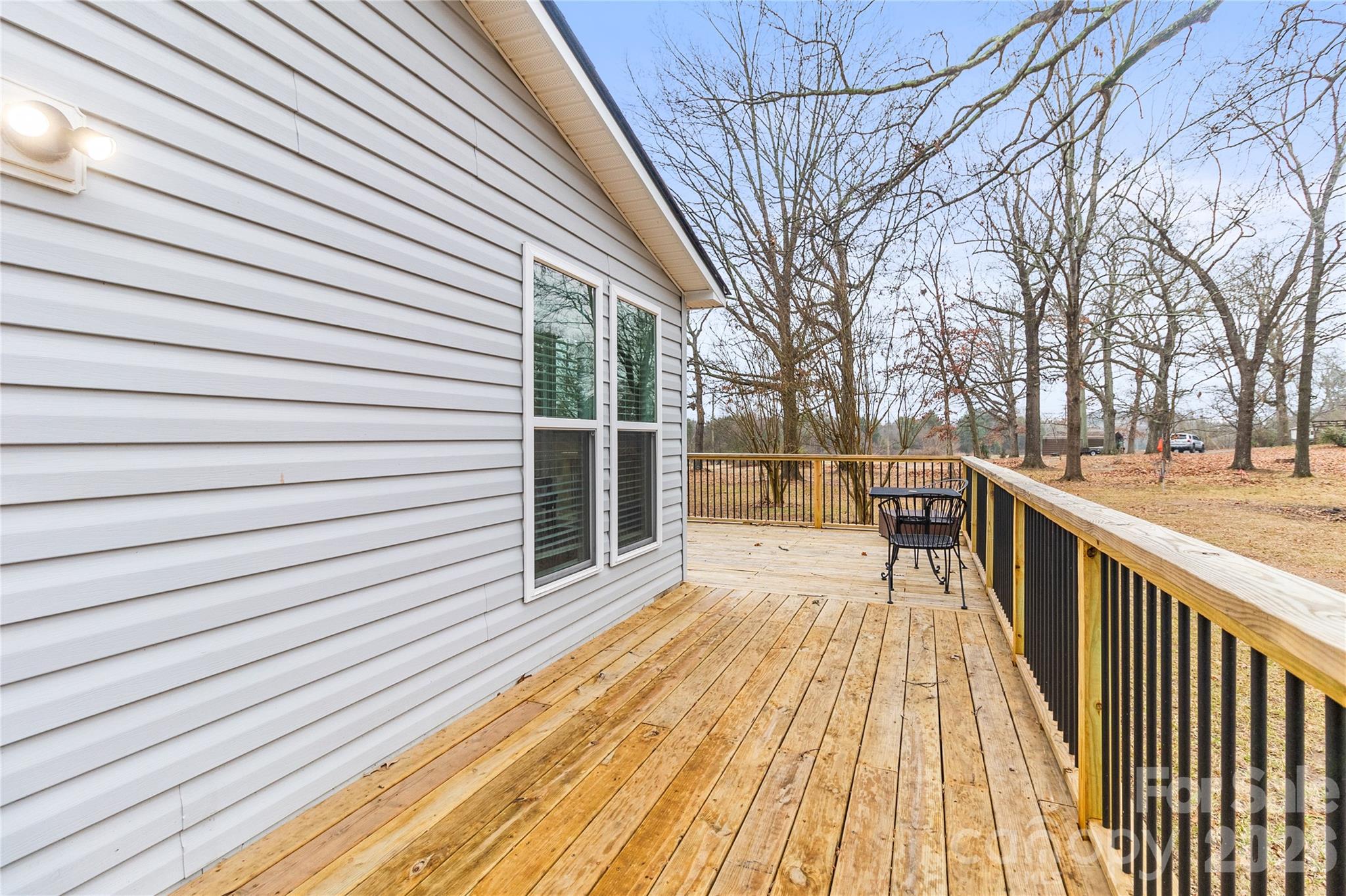 176 Odell School Road Concord, NC 28027 - Photo 12 of 46 a view of a balcony with wooden floor and fence and a couple of benches