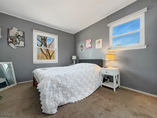 a bedroom with a bed and painting on the wall