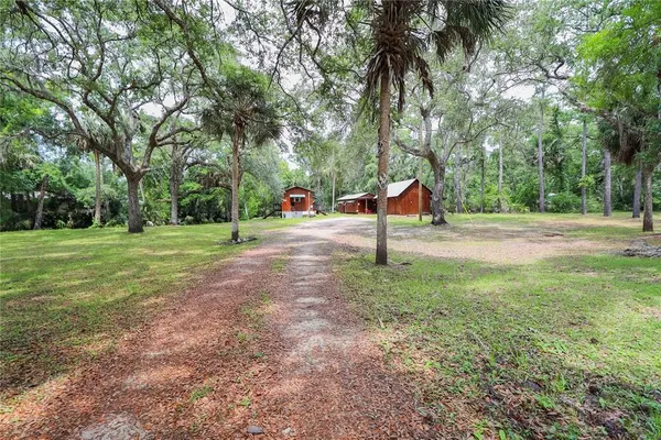 a view of a house with a yard and trees