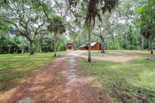 a view of a house with a yard and trees