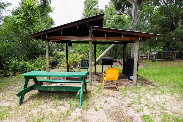 a view of backyard with table and chairs under an umbrella