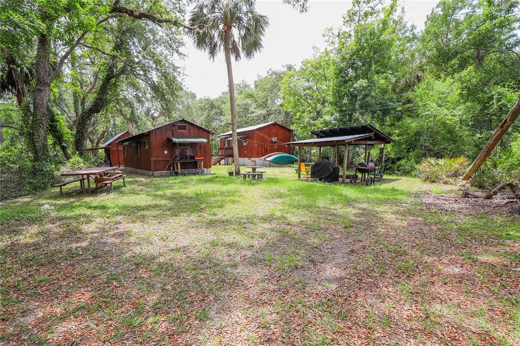3850 Southeast 22 Court Bronson, FL 32621 - Photo 2 of 40 a view of a house with a yard and large trees