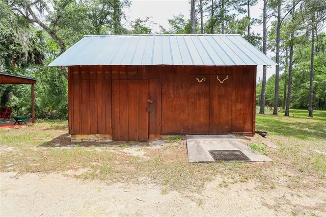 a view of wooden house with a yard and wooden fence