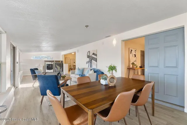 an empty room with wooden floor chandelier fan and windows