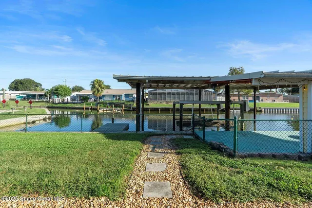 an aerial view of a house with a yard and lake view