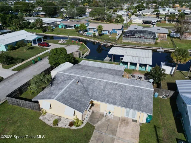 an aerial view of residential houses with outdoor space and trees