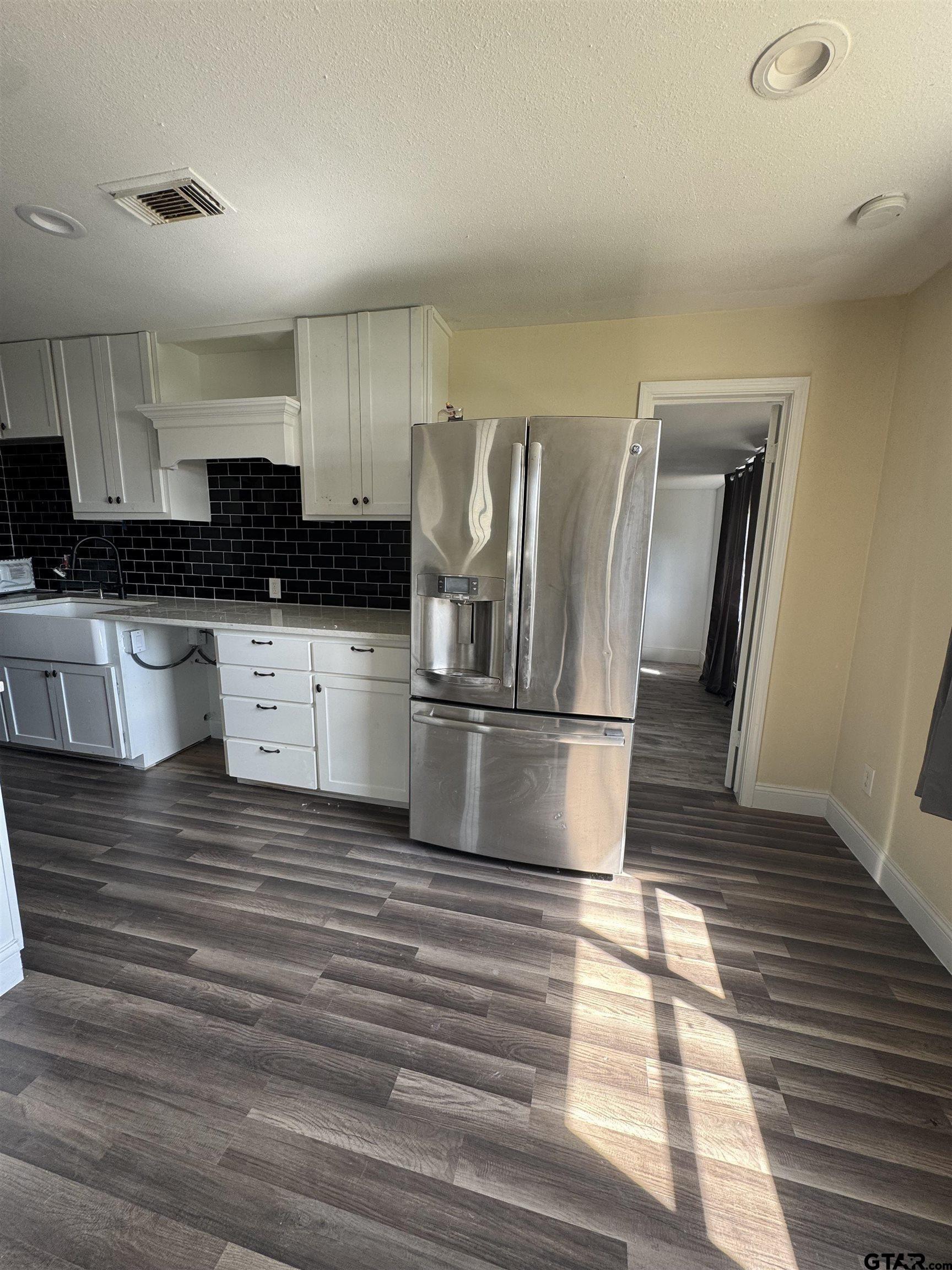 16238 Esther Road Lindale, TX 75771 - Photo 2 of 7 a kitchen with stainless steel appliances granite countertop a sink wooden cabinets and granite counter tops