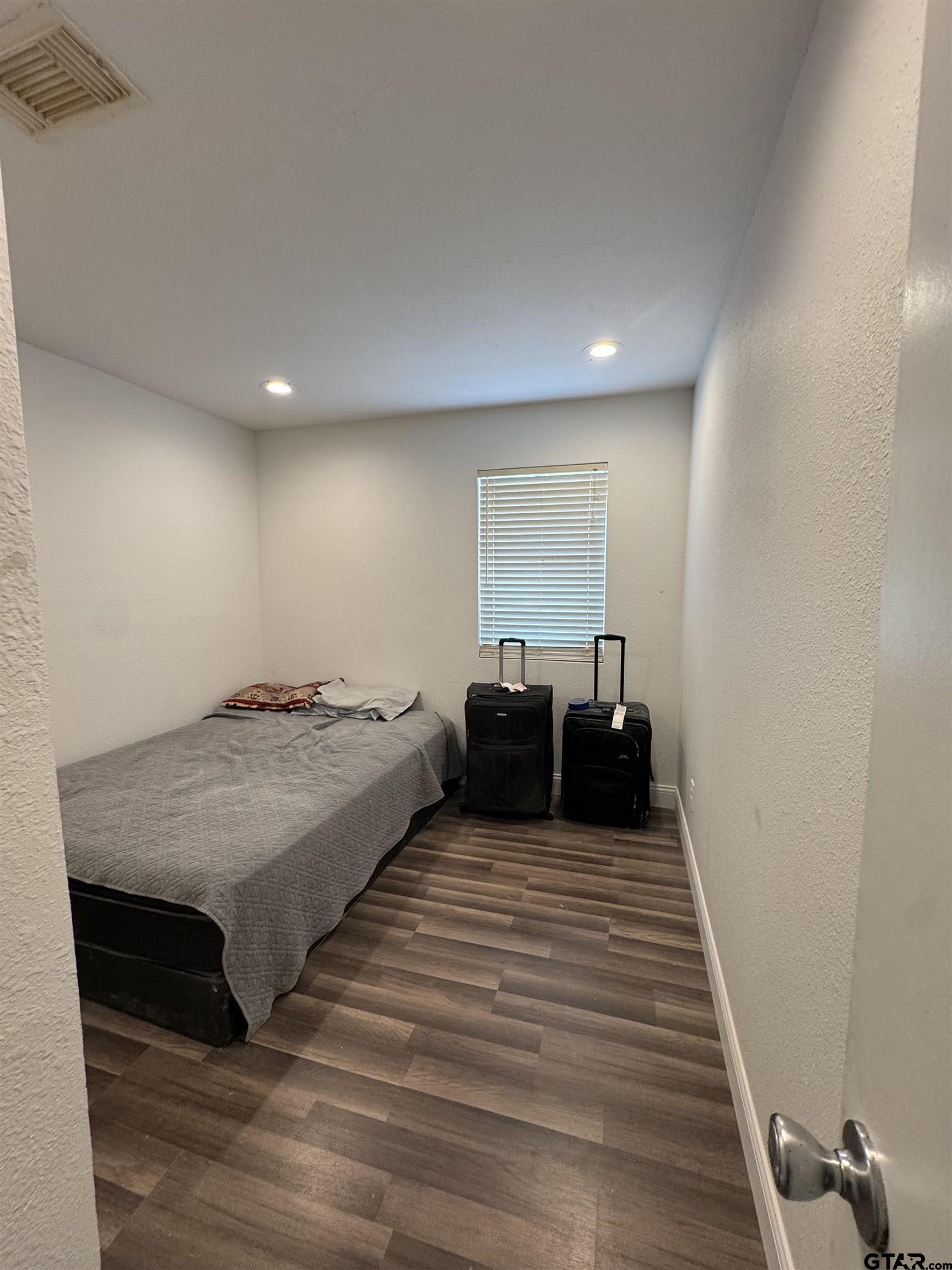 16238 Esther Road Lindale, TX 75771 - Photo 3 of 7 a spacious bedroom with a bed and wooden floor