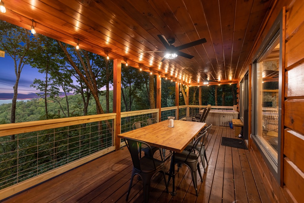907 Ripshin Mountain Road Blue Ridge, GA 30513 - Photo 37 of 55 a view of a patio with table and chairs with wooden floor and fence