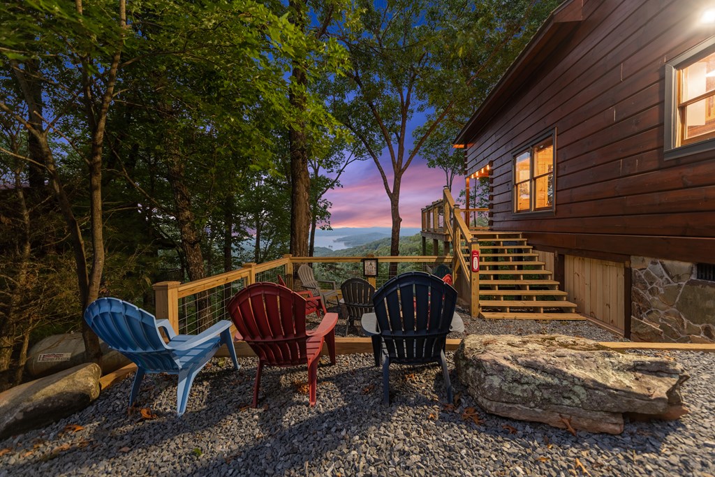 907 Ripshin Mountain Road Blue Ridge, GA 30513 - Photo 40 of 55 a view of a patio with table and chairs and floor to ceiling window