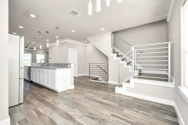a large white kitchen with kitchen island a stove a sink and a refrigerator