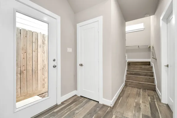 an empty room with wooden floor and entryway