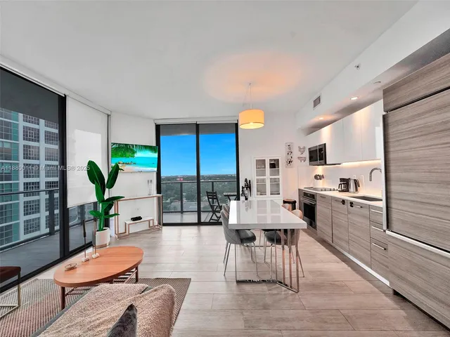 a living room with furniture and kitchen view