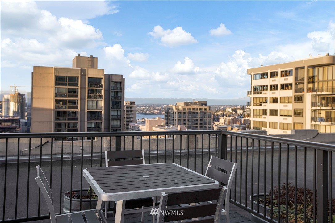 1105 Spring Street, Unit 1006 Seattle, WA 98104 - Photo 2 of 22 a roof deck with a barbeque and wooden floor