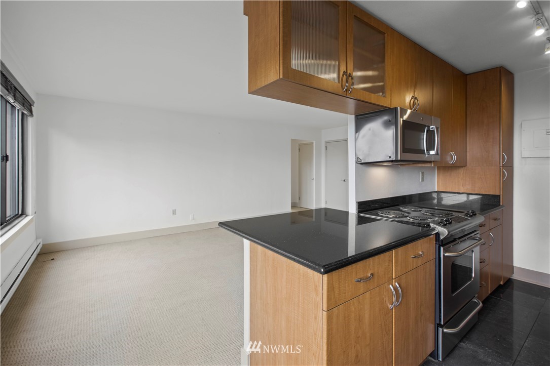1105 Spring Street, Unit 1006 Seattle, WA 98104 - Photo 11 of 22 a kitchen with stainless steel appliances granite countertop a stove a sink and a microwave