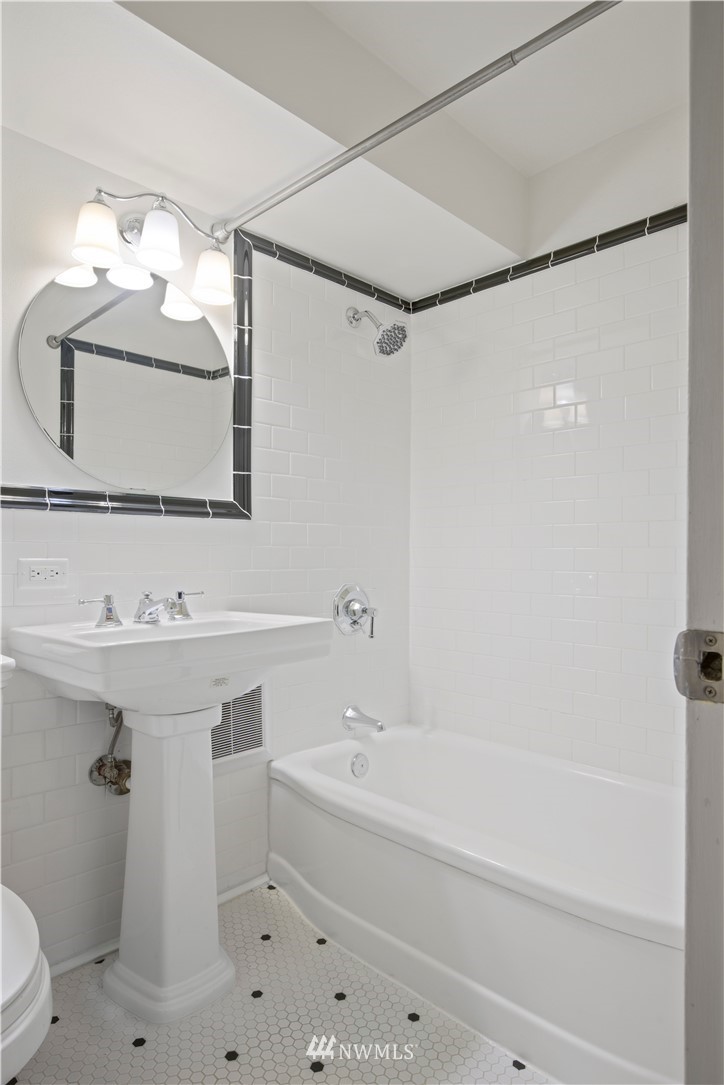 1105 Spring Street, Unit 1006 Seattle, WA 98104 - Photo 16 of 22 a bathroom with a sink a toilet and shower