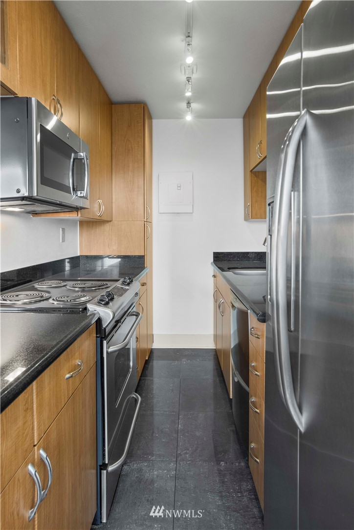 1105 Spring Street, Unit 1006 Seattle, WA 98104 - Photo 7 of 22 a kitchen with stainless steel appliances granite countertop a stove a refrigerator and a microwave