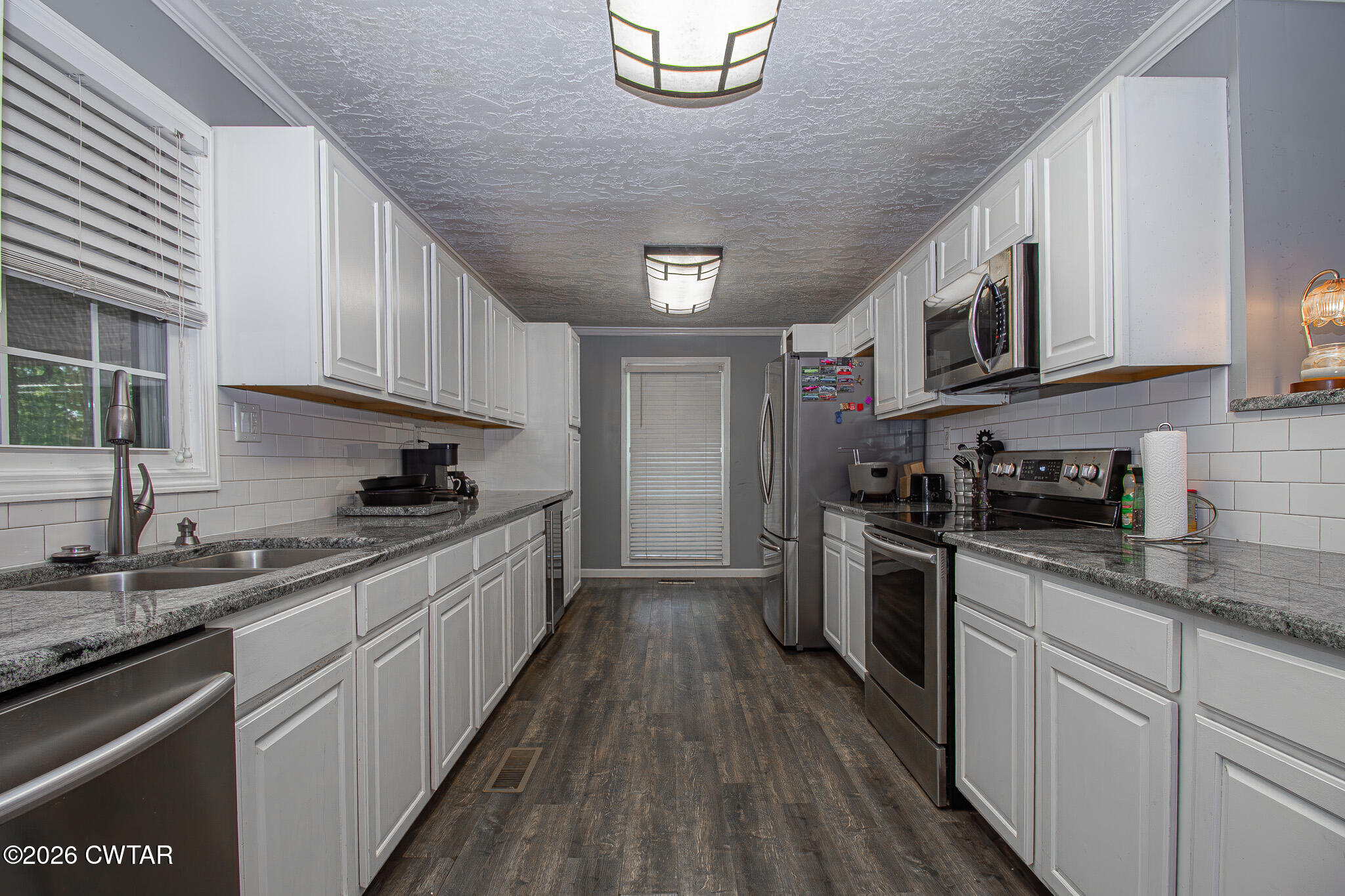 3075 Arnold Street Milan, TN 38358 - Photo 5 of 24 a kitchen with stainless steel appliances granite countertop a stove a sink dishwasher and a refrigerator