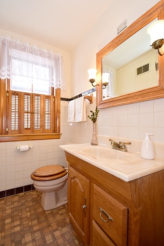 489 Uvedale Road Riverside, IL 60546 - Photo 13 of 25 a bathroom with a granite countertop toilet sink and mirror