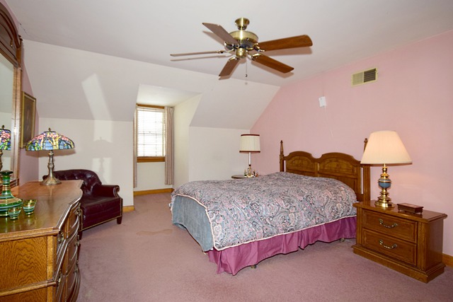 489 Uvedale Road Riverside, IL 60546 - Photo 14 of 25 a bedroom with a bed and dresser with chandelier
