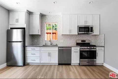 a kitchen with stainless steel appliances a stove a sink and a microwave
