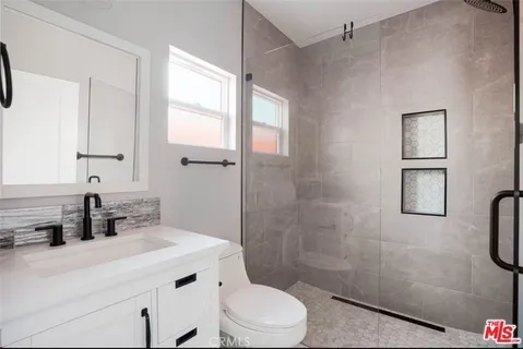 a bathroom with a sink a toilet and shower