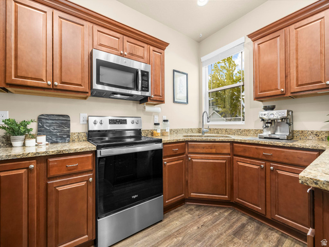 834 West 1050th Street South Springville, UT 84663 - Photo 8 of 26 Kitchen featuring extensive wood cabinetry, stone countertops, stainless steel appliances, and wood-finish flooring
