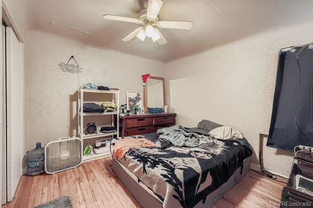 a bedroom with a bed and a flat tv screen on dresser